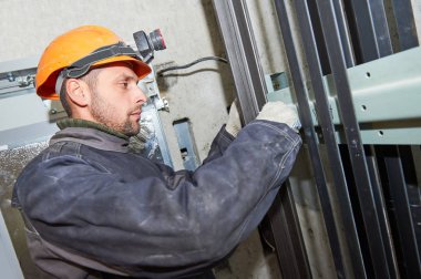 makinist Asansör boşluğuna asansör mekanizmasını ayarlama anahtarı ile