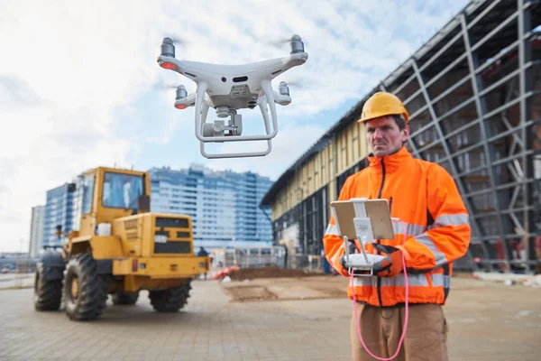 Drone operado pelo trabalhador da construção civil no estaleiro — Fotografia de Stock