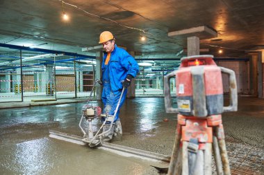 Beton zemin inşaat. İşçi screeder ile