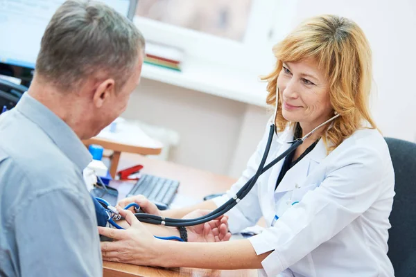 Medico sta controllando la pressione sanguigna del paziente — Foto Stock