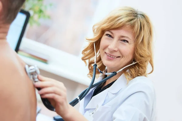 Physician doctor is checking the blood pressure of the patient — Stock Photo, Image