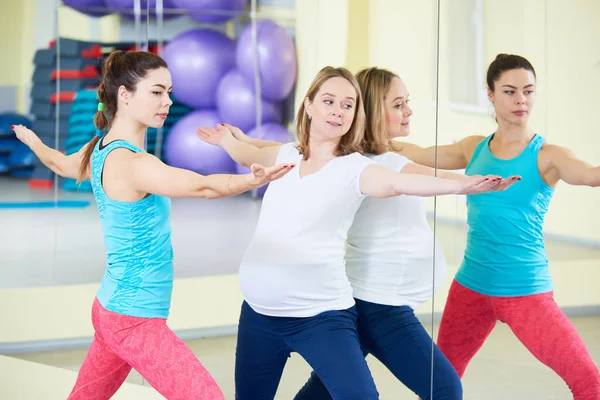 Těhotná žena dělá fitness cvičení s trenérem — Stock fotografie