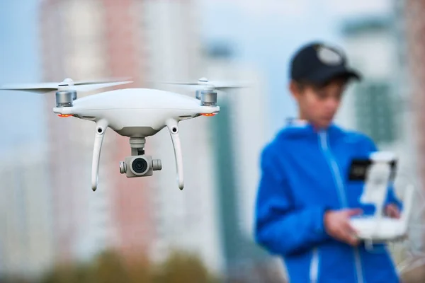 Young man werking van vliegende drone bij zonsondergang — Stockfoto