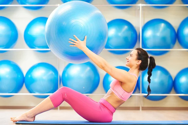 Frau turnt mit Fitnessball — Stockfoto