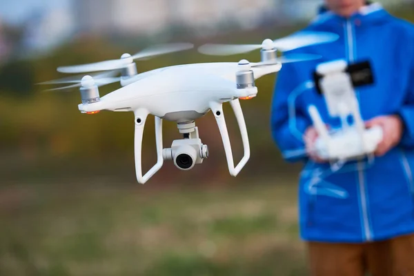 Young man werking van vliegende drone bij zonsondergang — Stockfoto