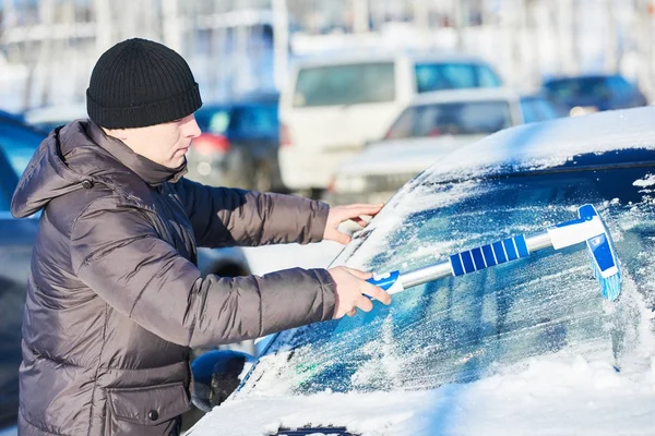 Mann reinigt Auto vom Schnee — Stockfoto