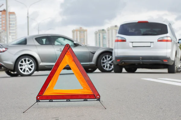 Accidente o accidente con dos automóviles. Señal de triángulo de advertencia vial en foco —  Fotos de Stock