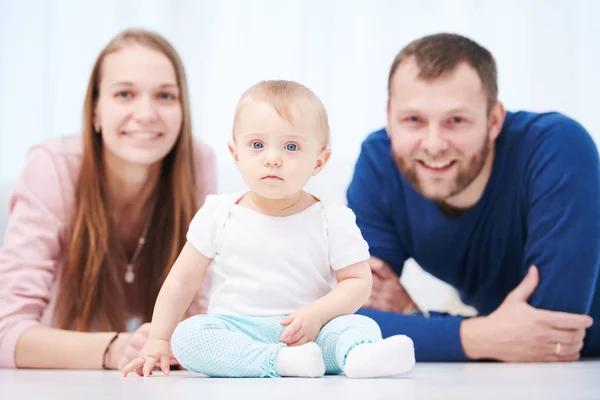 Ebeveyn ailesi. Anne ve baba yeni doğmuş bebekle oynuyorlar. — Stok fotoğraf