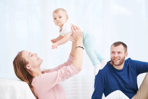 Rodzicielska rodzina. Mama i ojciec bawią się z małym noworodkiem — Zdjęcie stockowe