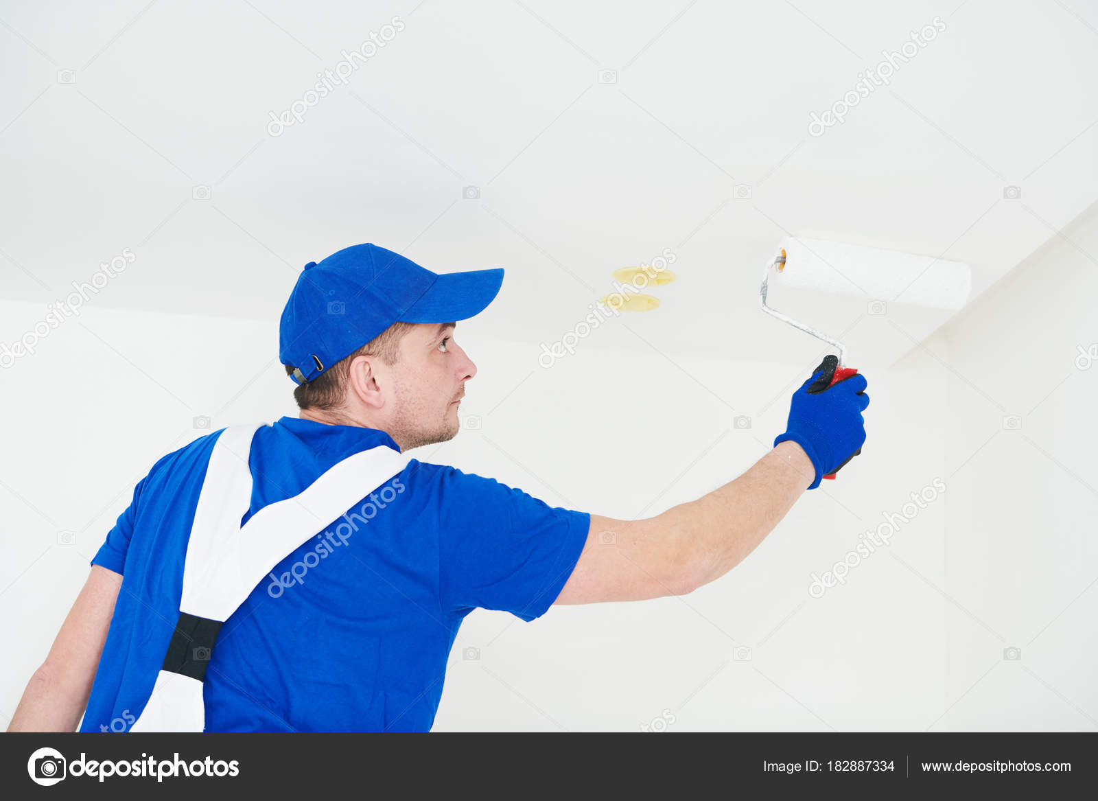 Painter Painting Ceiling With Paint Roller Stock Photo