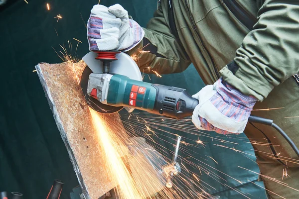 Trabajador molienda corte hoja de metal con máquina amoladora y chispas —  Fotos de Stock