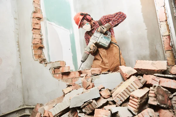 Ouvrier avec marteau de démolition brisant mur intérieur — Photo