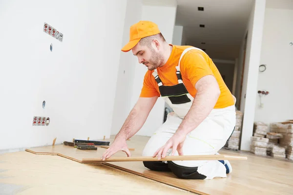 Trabajador uniéndose al suelo de parquet . —  Fotos de Stock