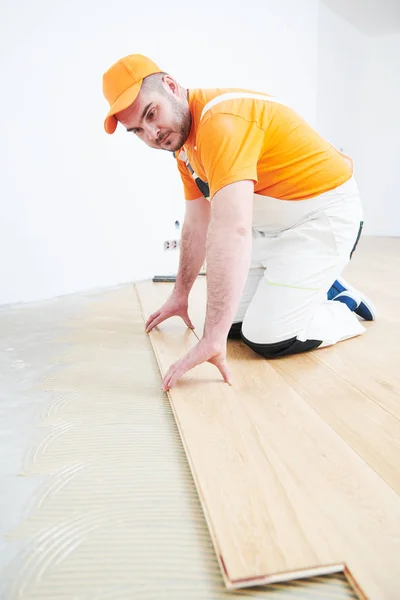 Trabajador uniéndose al suelo de parquet . —  Fotos de Stock