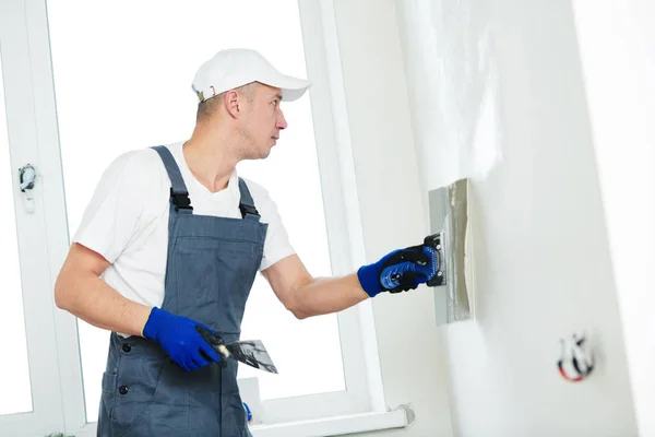 Enlucido. Trabajador salpicando una pared con masilla — Foto de Stock