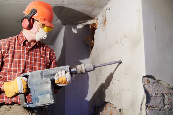 Ouvrier avec marteau de démolition brisant mur intérieur — Photo