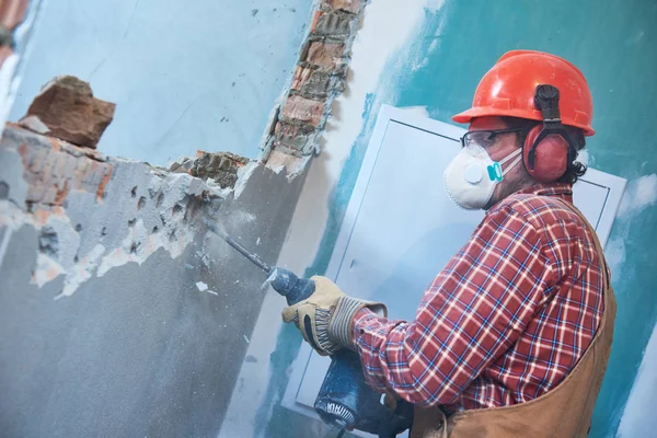 Trabajador con martillo de demolición rompiendo la pared interior —  Fotos de Stock