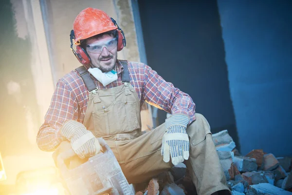 Rompiendo la pared interior. retrato de trabajador con martillo de demolición —  Fotos de Stock