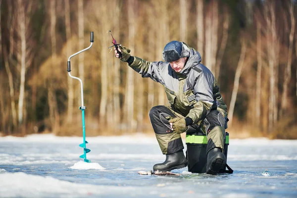 Winter fishing on ice. Fisherman hooking fish. Biting — Stock Photo, Image