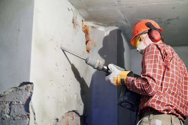 Ouvrier avec marteau de démolition brisant mur intérieur — Photo