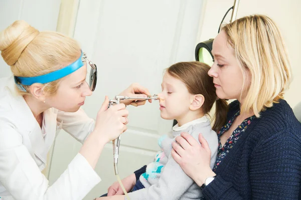 Médico fêmea de otorrinolaringologia no trabalho examinando nariz de menina — Fotografia de Stock