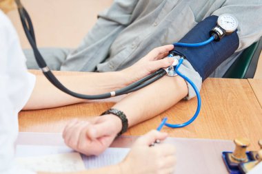 Doktor Doktor hastanın kan basıncını kontrol ediyor