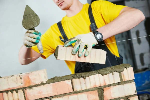 Pedreiro construtor trabalhador colocação de tijolos parede — Fotografia de Stock