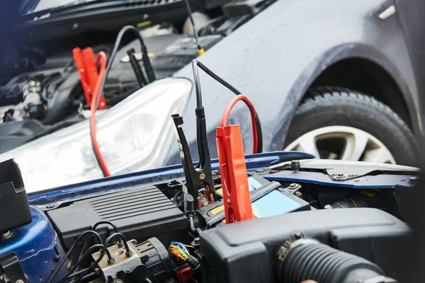 Ajuda no automóvel. cabos jumper booster carregando bateria descarregada automóvel — Fotografia de Stock