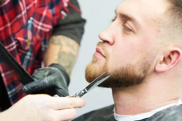 Baard verzorging. man terwijl zijn gezichtshaar te trimmen op de barbershop gesneden — Stockfoto