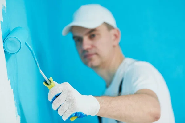 Trabalhador pintor com superfície de parede de pintura de rolo — Fotografia de Stock