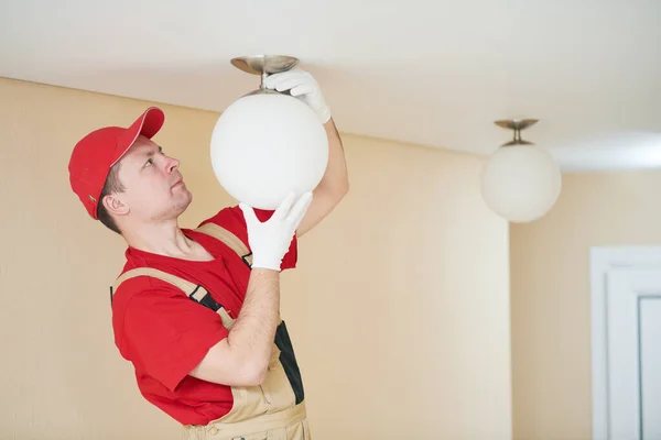Electricista trabaja con lámpara de techo. servicio de instalación o reparación —  Fotos de Stock