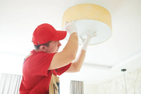 electrician works with ceiling lamp. installing or repair service