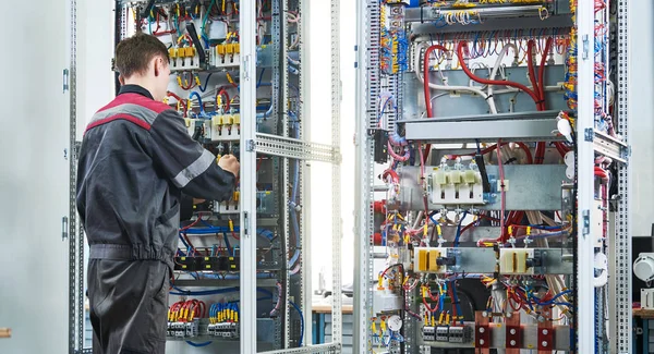 O eletricista trabalha com alicates na caixa de distribuição. instalação do disjuntor atual — Fotografia de Stock