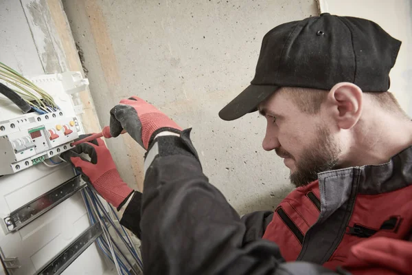 Elektricien werkt met schakelkast. installatie van een stroomonderbreker — Stockfoto