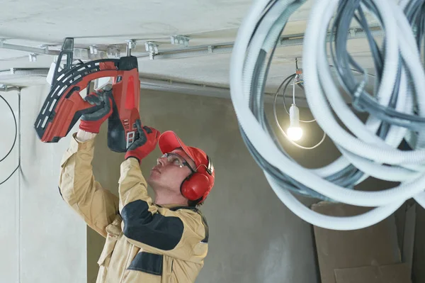 Elektrikář. Držák přibíjecích trubek instalátoru pro vedení kabelů — Stock fotografie