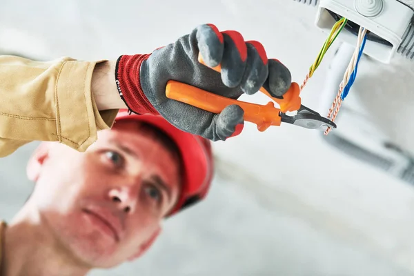 Electrician service. Installer works with cable in junction box — Stock Photo, Image