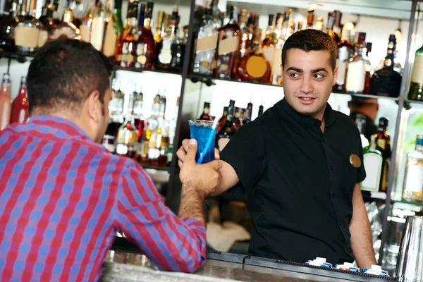 Barman pracovník servíruje koktejl k baru klienta — Stock fotografie