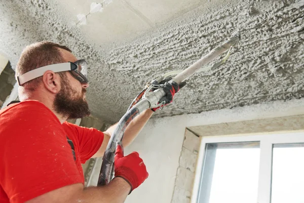 Gesso utilizzando macchina spruzzatore mettendo malta intonaco sul soffitto — Foto Stock