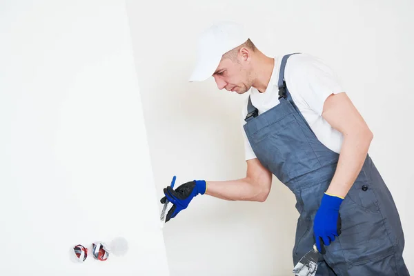 Sanierung. Arbeiter bearbeiten eine Wand mit Spachtel — Stockfoto
