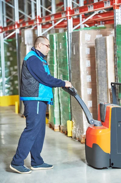 Worker with pallet truck loading cardboxes — Stock Photo, Image