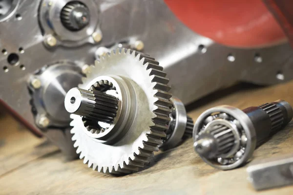 Metal cog wheel gears near gear box — Stock Photo, Image