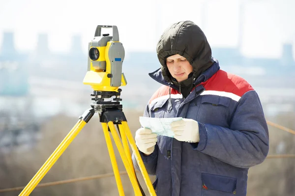 Surveyor pracovník s teodolit na staveništi — Stock fotografie