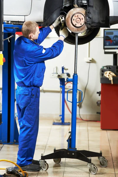 Service de réparation automobile. Mécanicien inspectant les freins et les plaquettes de voiture — Photo