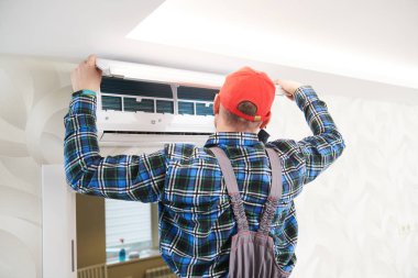 Klima servisi. İklim sistemi kurulumunda çalışan işçiler