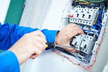Elektrikçi, tornavidayla telefon kulübesinde çalışır. güncel kırıcı kurulumu
