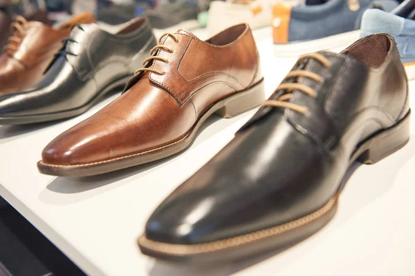 Calçado masculino a vender. Sapatos de couro formais na prateleira na vitrine da loja — Fotografia de Stock