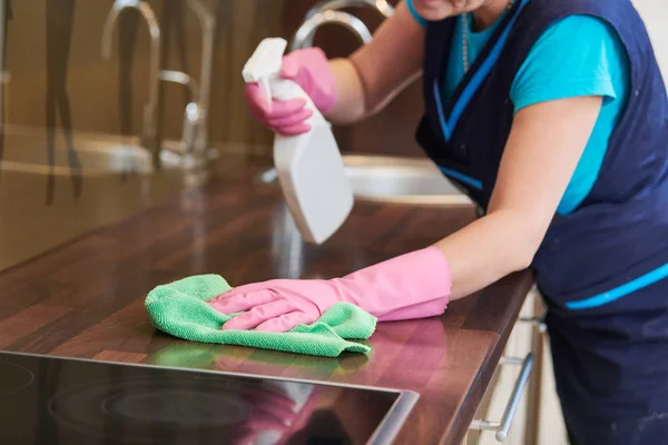 Serviço de limpeza. limpando armário de cozinha com pano e líquido — Fotografia de Stock