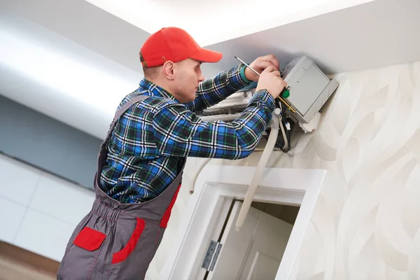 Servicio de aire acondicionado. Trabajador en instalación de sistemas de climatización en interiores — Foto de Stock