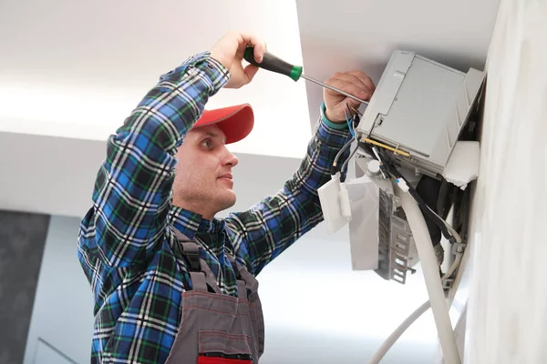 Servicio de aire acondicionado. Trabajador en instalación de sistemas de climatización en interiores — Foto de Stock