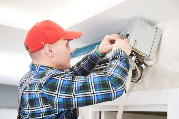 Air conditioner service. Worker at climatization system installation indoors